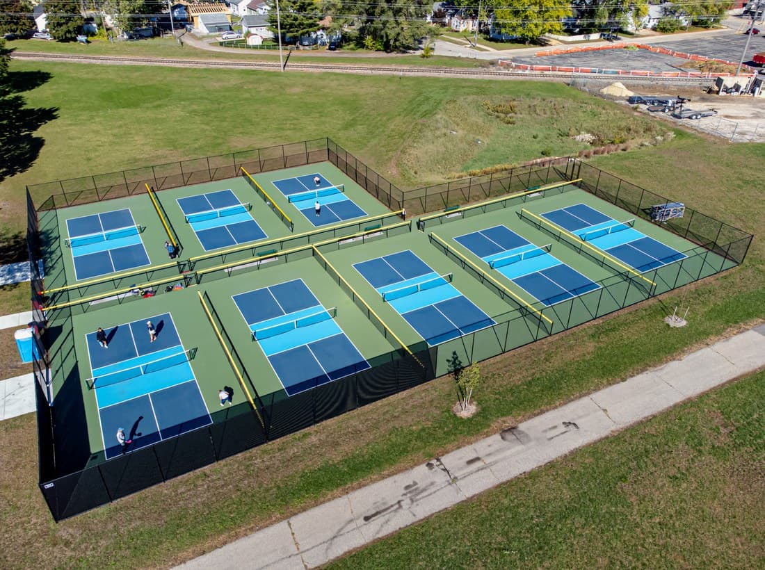 A row of pickleball courts seen from above, with players on them